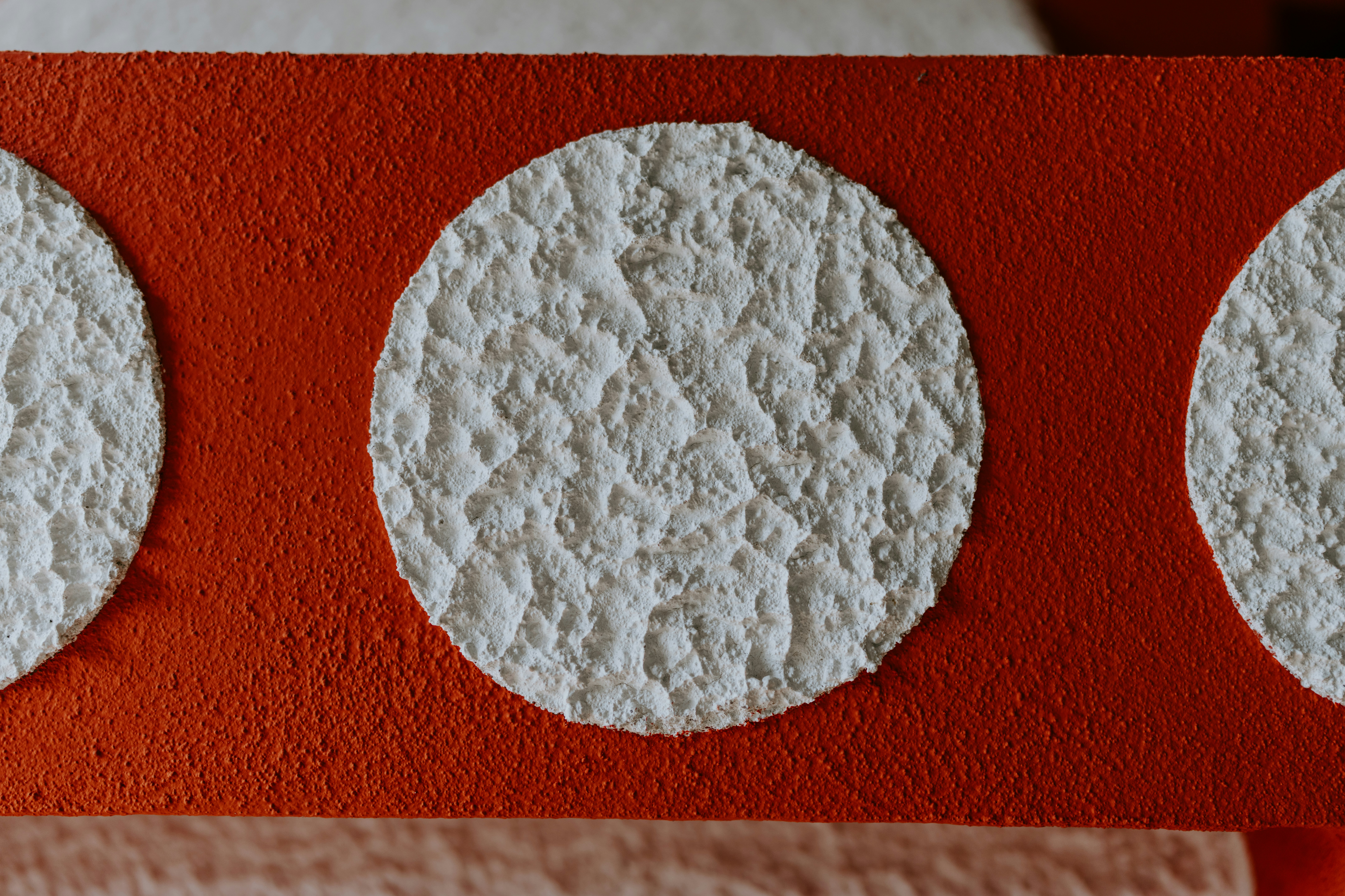 white round ornament on red textile